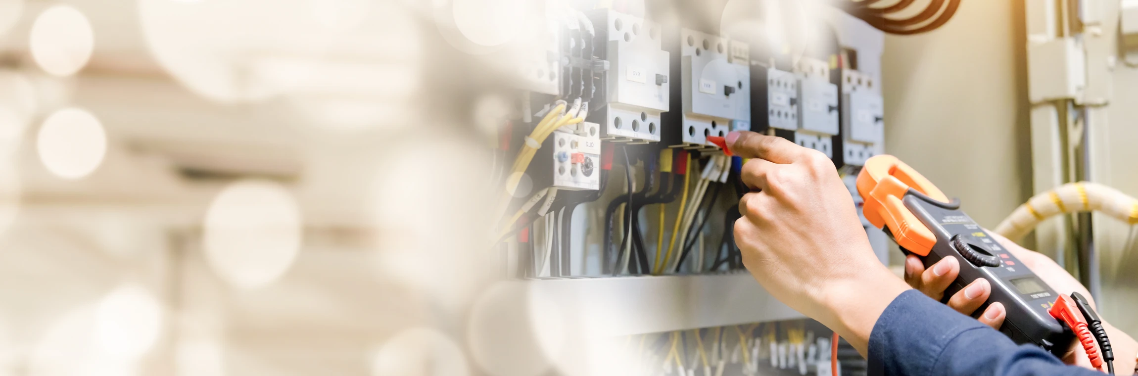Essai de travail de l'électricien-ingénieur mesurant la tension et le courant de la ligne électrique dans le contrôle de l'armoire électrique