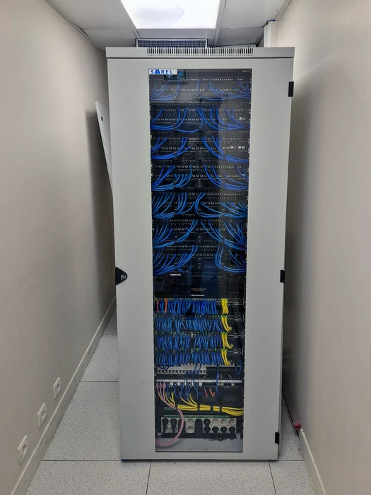 Baie de brassage informatique SAREL 42U en salle serveur, avec porte vitrée
