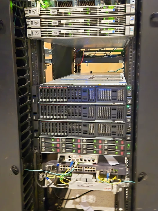 Technicien en pull bordeaux travaillant sur équipement de télécommunications dans baie de brassage