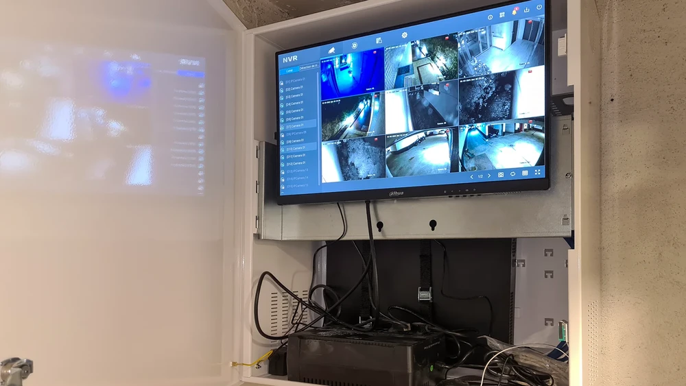 Int&eacute;rieur r&eacute;sidentiel, technicien installant une cam&eacute;ra de surveillance fix&eacute;e au plafond